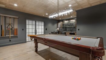 Recreation,Room,With,Large,Wooden,Pool,Table,And,Glass,Doors