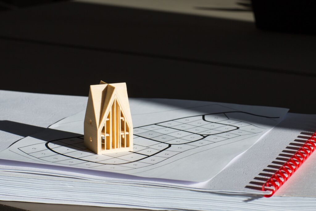 model of house is on survey map on table