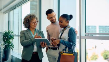 real estate agent using digital tablet with her clients during consultations in the office