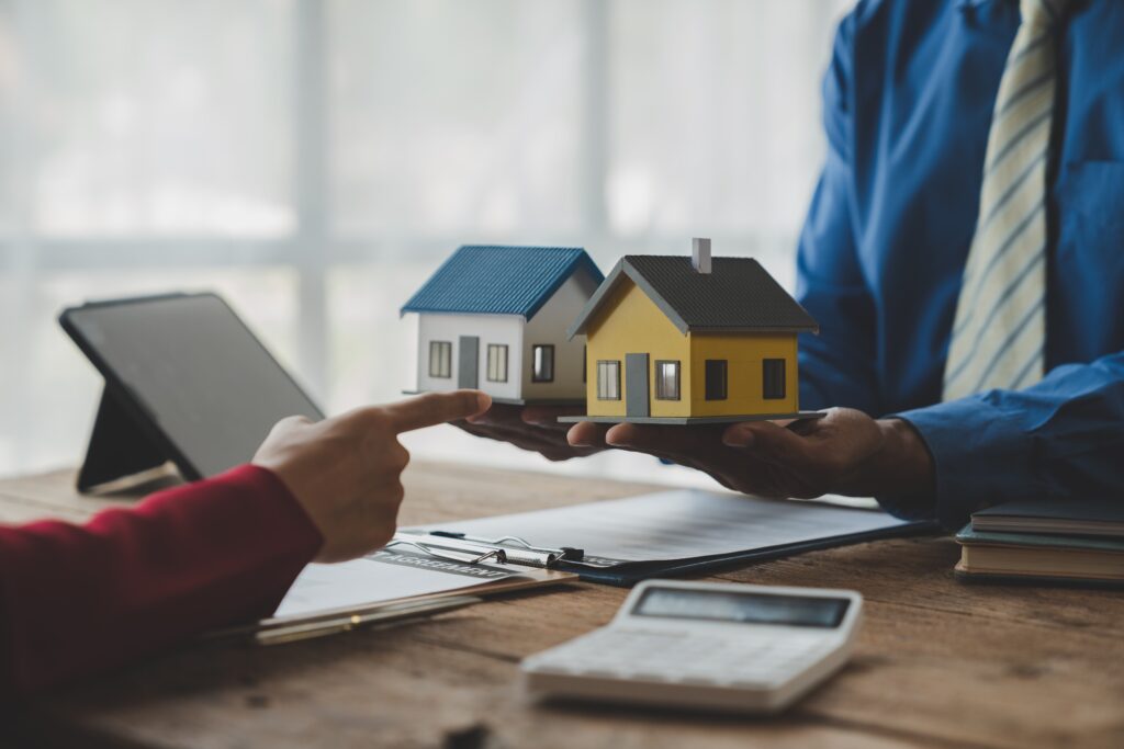 Real estate agent presents model homes to a client to choose from